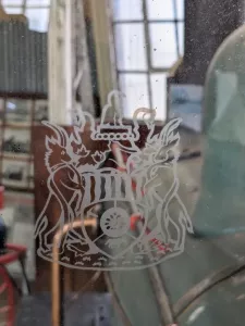 In Glas geschliffenes Wappen der Eisenbahngesellschaft